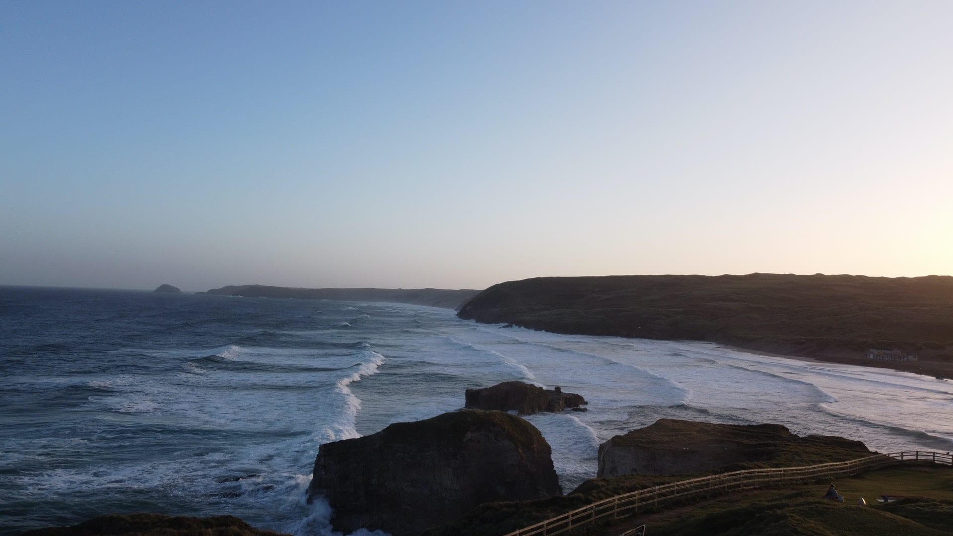 View looking down from the cliff on waves at Perranporth beach